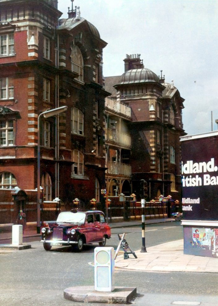 Knowledgepoint's tweet image. 1960s, Sydney St/Kings Rd, infirmary wing of the Workhouse still exists, although that central section is gone now. The billboard on the right is where the Chelsea Palace used to be – music hall, theatre, cinema, TV studios and even a bingo hall in its time.