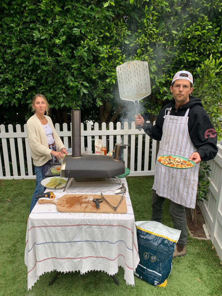 In my spare time I have become a semi-pro pizza maker. Hire me for your Bar Mitzvah, wedding, graduation, or other special occasion. Last night, this stylish apron was provided by my sous-chef sister, who is skillfully no-look applying the toppings in this photo.