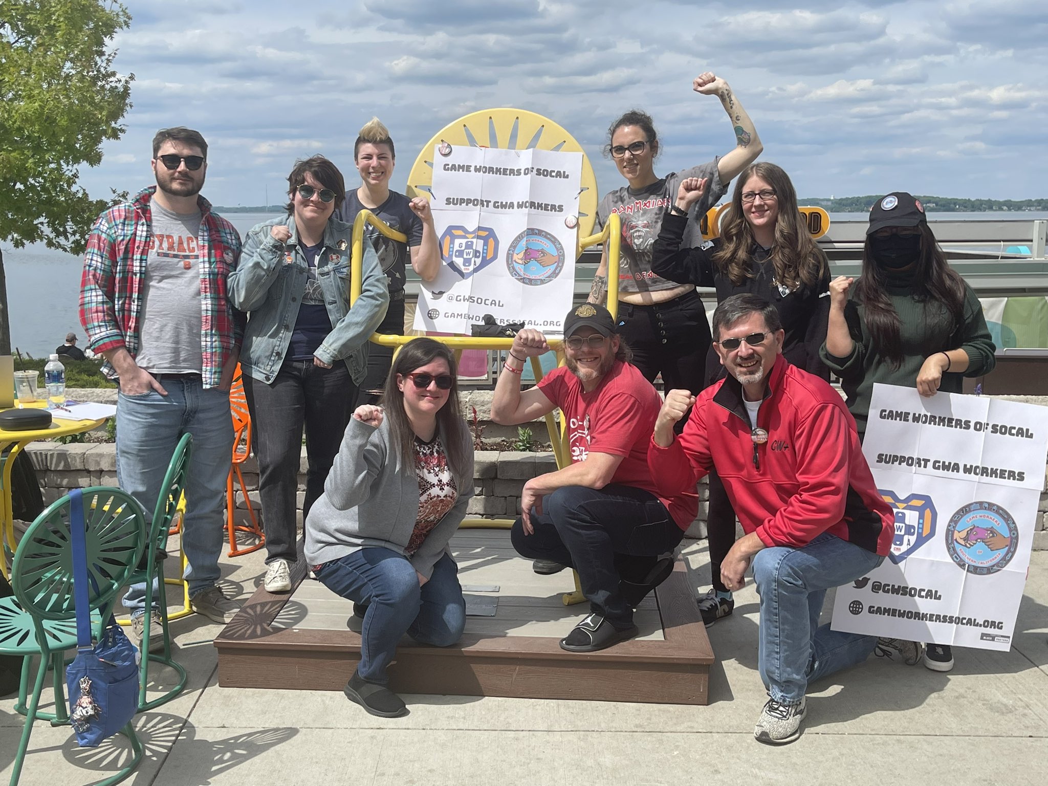 Image of Raven Software members with signs that mention game workers of southern california, and to support GWA workers with their fists in the air