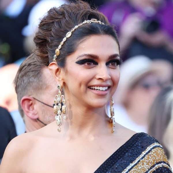 etimes's tweet photo. .@deepikapadukone was seen wearing the headband with two of her outfits. 

She wore a beaded headband which paid homage to the traditional Indian matha patti with her black and gold sequinned sari and a scarf band with her casual shirt and green pants. https://t.co/kEJ4yEE1h6