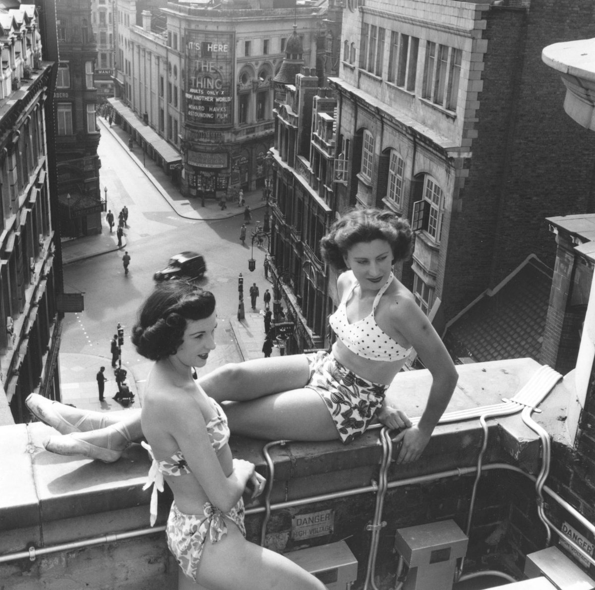 Women sunbathing, Piccadilly Square, London, 1953. In the background the cinema is showing The Thing from Another World.