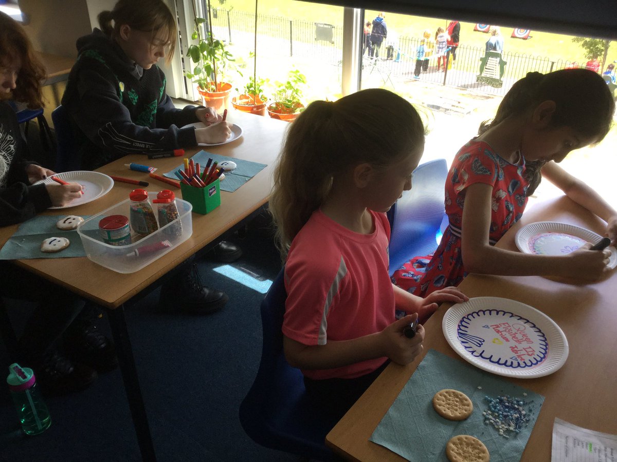 Icing royal biscuits for a tea party.