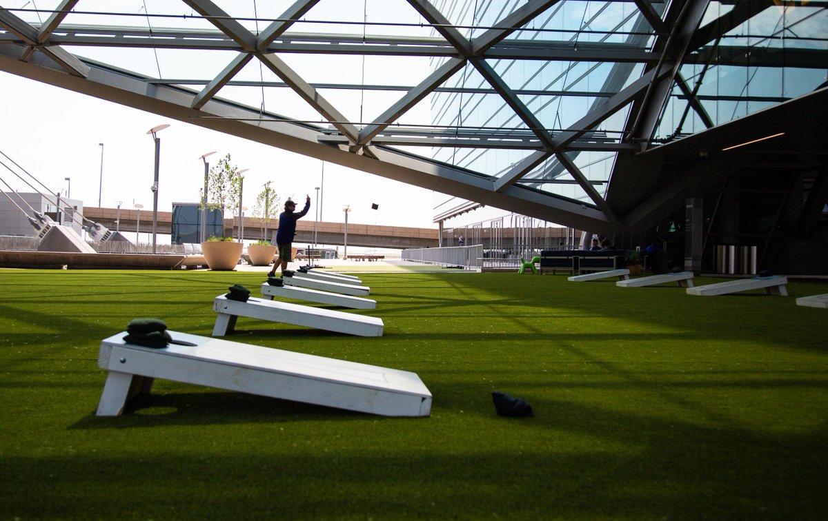 DENAirport's tweet photo. DEN's Park on the Plaza is now open daily through Oct. 2! Play a game of corn hole, relax on the grass-like turf or chill on lounge seating while enjoying Colorado-native plants and trees. Kick your feet up and stay a while (but don't be late for your flight 😉) 🌳 🤸♀️ #DENevents https://t.co/actvKJmay4