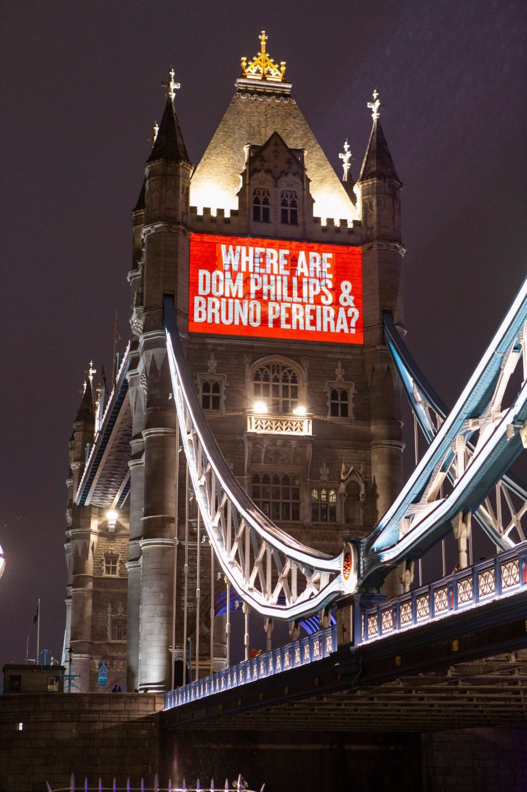 Torre de Londres iluminada e no alto a projeção com fundo vermelho e letras brancas onde se lê where are Dom Phillips e Brüno Pereira?