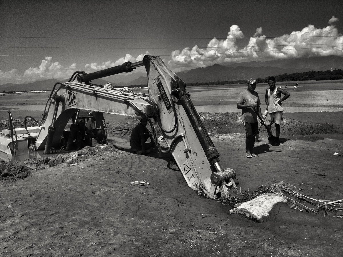 AratiKumarRao's tweet photo. @NGhanekar It’s hard to fathom. 

Here, a tiny #EasternHimalayan river — a tiny tributary of the #Brahmaputra — carrying silt+sand burst thru an embankment in #UpperAssam, dumped its load on a paddy field. A JCB on the road got buried — can only see its arm

Just imagine the total load :) https://t.co/EmFIfjXeA6