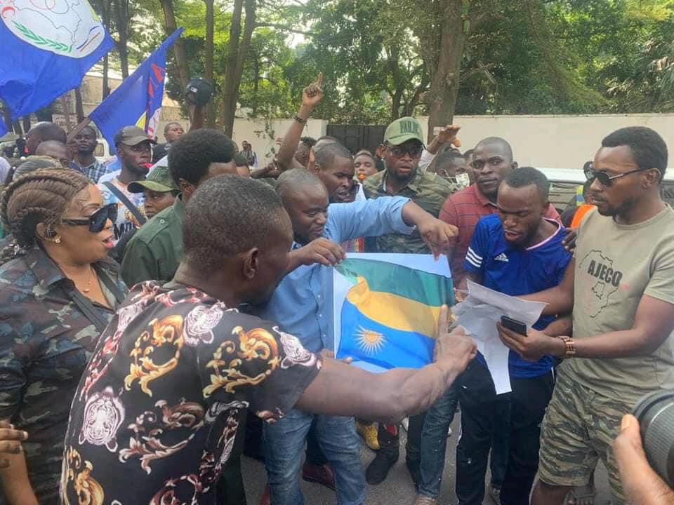 rwandaiskilling's tweet photo. #RDC : Manifestation ce lundi  des Congolais  devant l’ambassade du Rwanda à Kinshasa. Ils exigent la fin totale des relations diplomatiques avec le pays de Paul kagame , le drapeau du Rwanda brûlé par les manifestants.

#RwandaIsKiling https://t.co/hwFBtycRa2