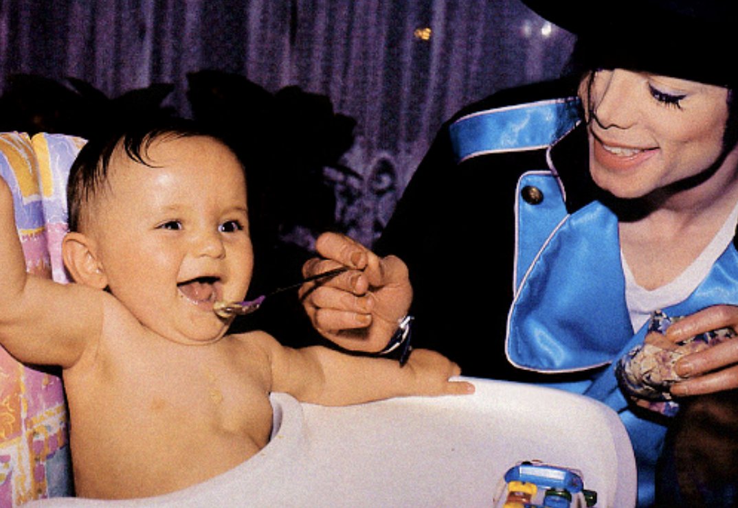 1minus1equal35's tweet photo. A photo of Michael Jackson feeding his son Prince. https://t.co/Atmeom1WQQ