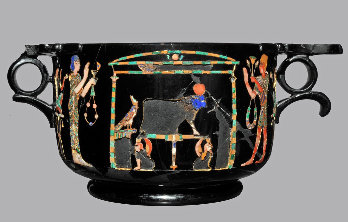 A stunning obsidian skyphos (cup), inlaid with malachit, lapis lazuli, white and rose coral, and gold leaf, depicting an adoration scene: a temple, inside the Apis Bull, flanked by a Horus Hawk and a Thot-Ibis. A female figure is standing left of the …1/2 

#RomanArchaeology