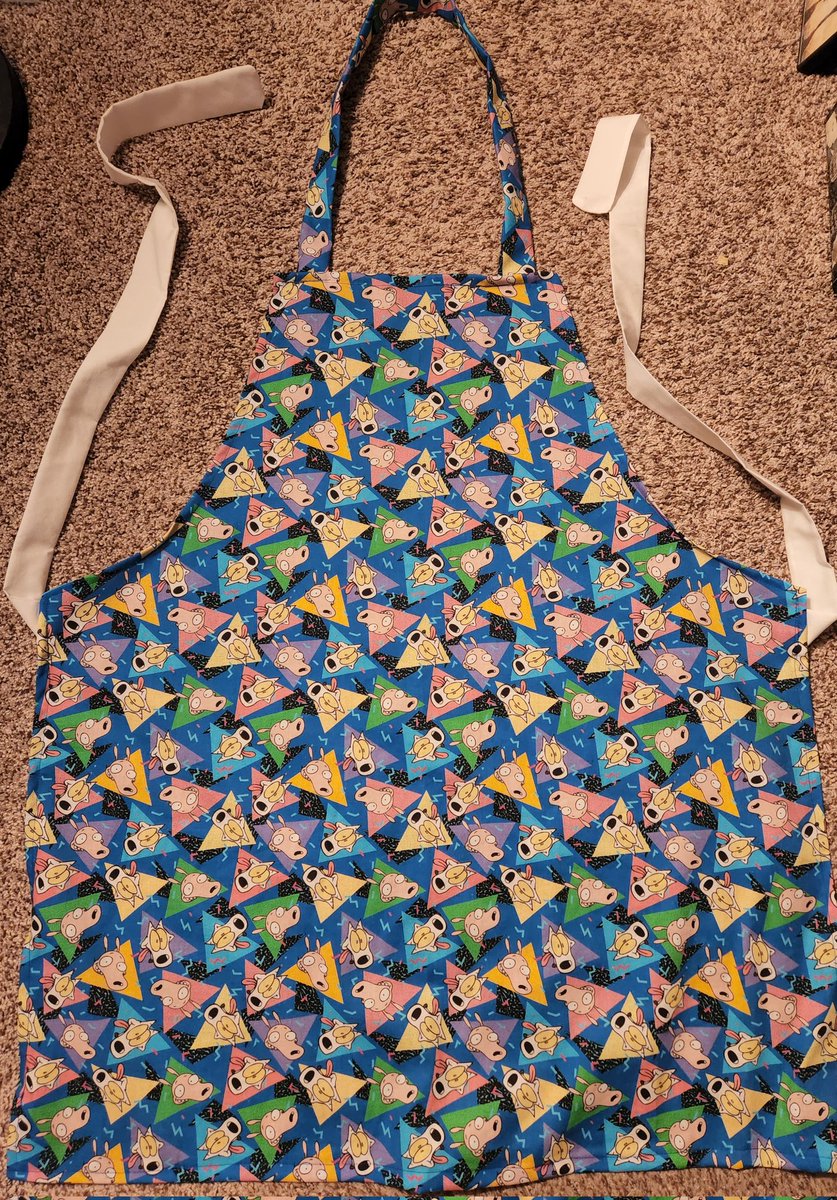 I have another rocko's modern life apron for you! It's in a fun 90s print with rocko and spunky. 
Made with 100% cotton
One size good all/most. 
Pulls overhead, ties at the waist.

Link in bio