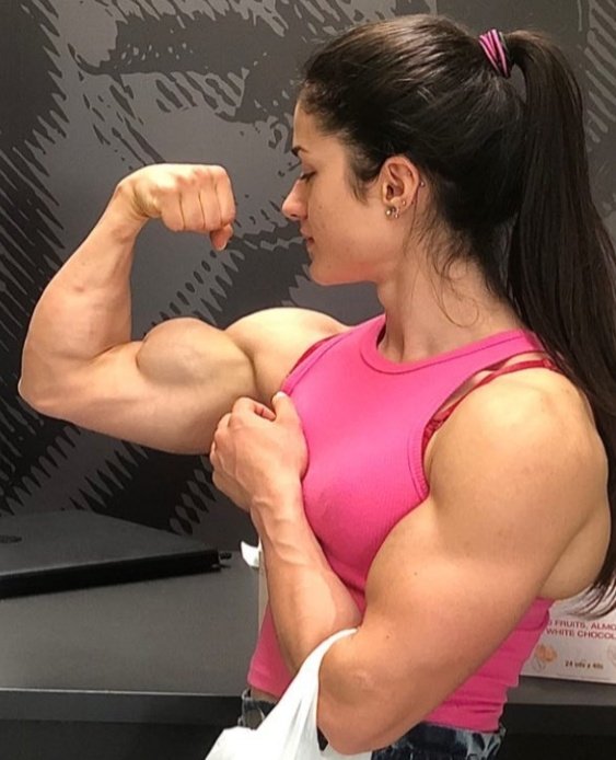 Female athlete flexing her biceps at the gym on Craiyon