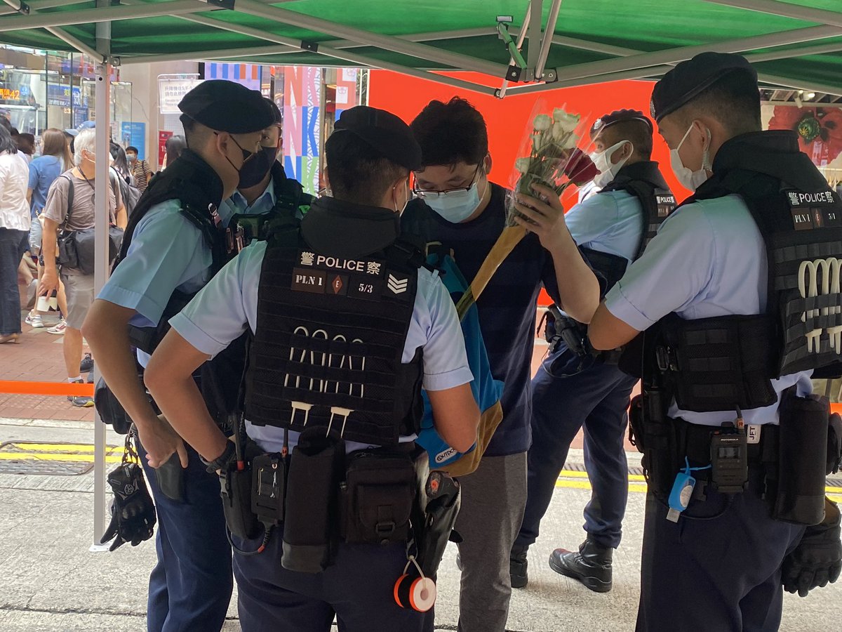 A man is being stopped and checked by the police. They requested him to put the flowers inside his bag. #June4 #HongKong