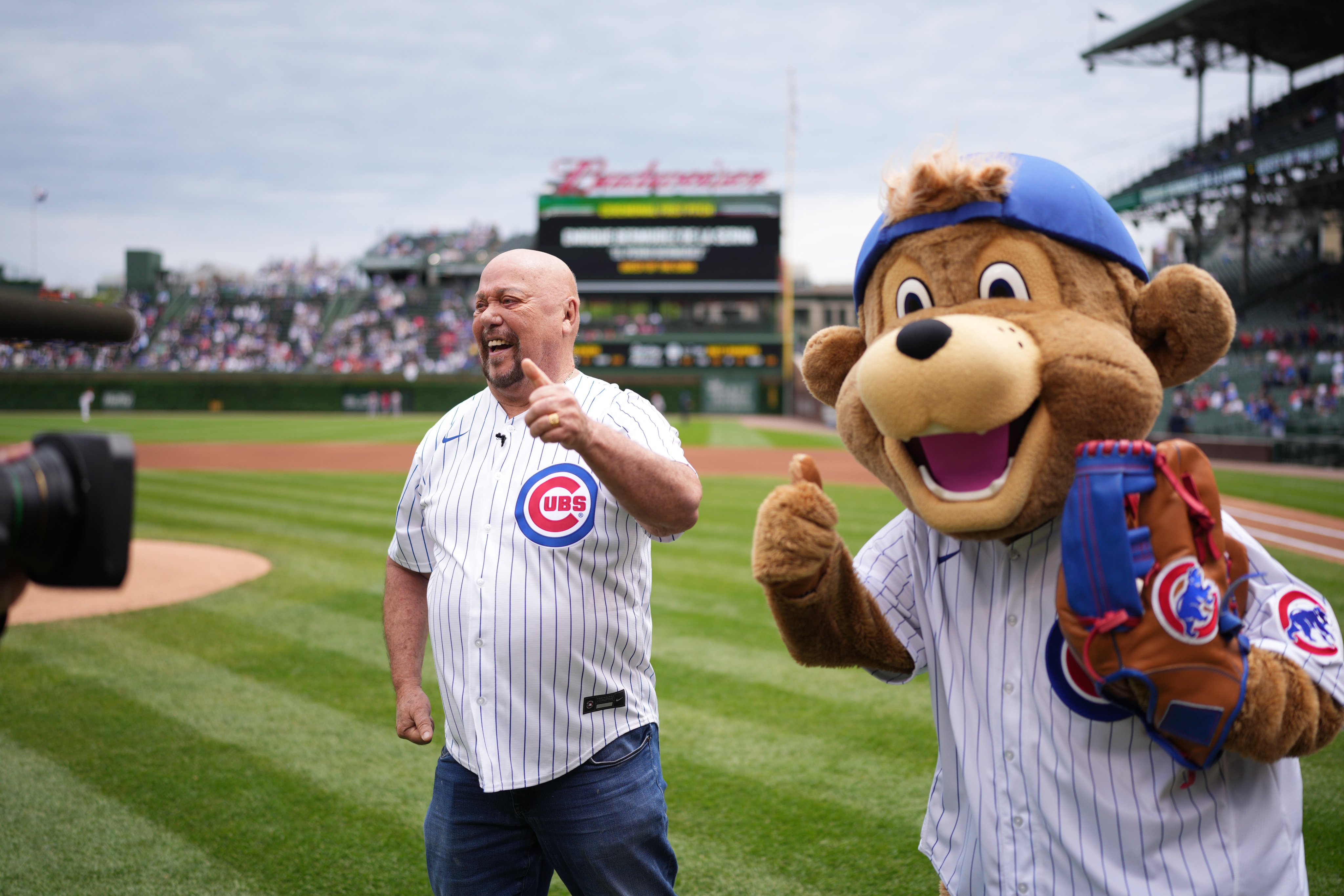 Enrique Bermudez de la Serna from Televisa Univision smiles and gives a thumbs up in a posed photo with Clark the Cub after throwing a ceremonial first pitch at Wrigley Field on Saturday. (Photo: Matt Dirksen/Chicago Cubs)