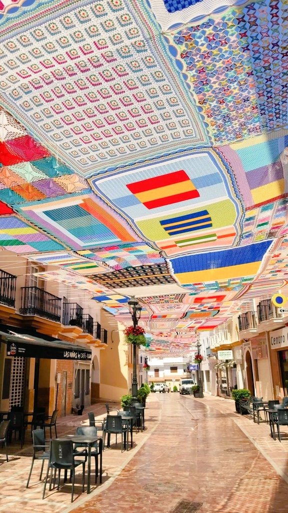 Spanish crochet teacher Eva Pacheco and her students created a huge, colourful street canopy in crochet and knitting, making welcome shade for the community of Alhaurín de la Torre, Malaga #WomensArt ❤