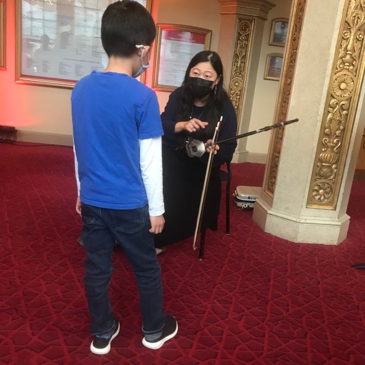sound_of_dragon's tweet photo. Lan Tung on #erhu and voice and Aram Bajakian on #oud at the Vancouver Symphony Orchestra #dayofmusic.
Photo of a curious chap who wanted to learn more about the incredible 2-stringed erhu and a second photo of the 2 musicians focused on the improvisation going on. https://t.co/A26zT2hCpw
