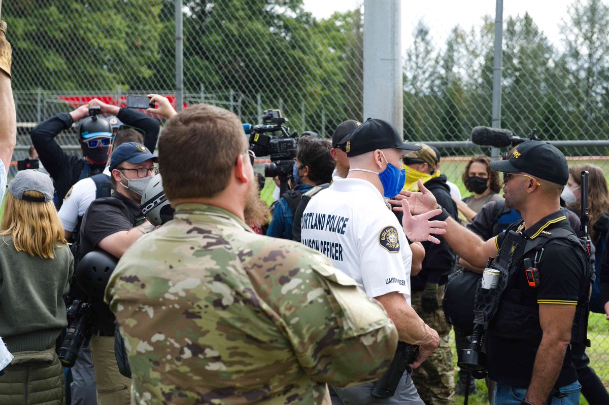 baaascom's tweet photo. Seems like a good day to tweet out these pictures of Portland Police taking directions from Enrique Tarrio on September 27, 2020 at Delta Park within minutes of Proud Boys stomping out a photographer. https://t.co/HriD4enmQI