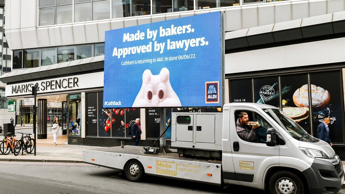 CornflakesMedia's tweet photo. Aldi, a German discount supermarket chain, launched its Colin the Caterpillar lookalike cake, and found themselves embroiled in a high court trademark case by M&amp;S, and removed from the shelves, but now he is back – and Aldi celebrated by parking billboards outside M&amp;S stores. https://t.co/AkLV1LolDG