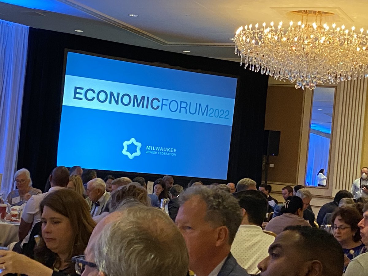 Collaborating for the future economic vitality of Mikwaukee Economic Forum 2022 in the Pfister Grand Ballroom. Thank you to Mikwaukee Jewish Federation for your commitment to Mikwaukee. Themes are innovation and building trust.