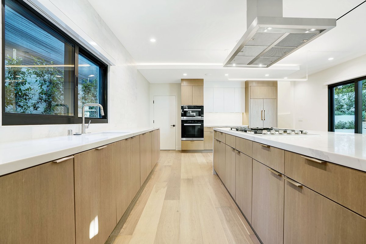 Open kitchen design in #palosverdesestates that interlocks the kitchen island and dining table. Eliminates the need for a separate underutilized dining room #architecture #californiahomes #house #kitchendesign #residentialarchitecture   photos by iconsmktg.com