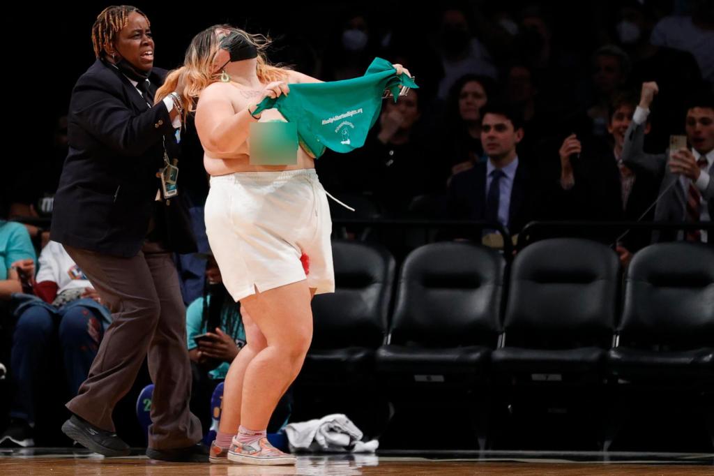 nypost's tweet photo. Topless pro-choice protesters run onto court at WNBA game in Brooklyn https://t.co/fJTh8wSsAy https://t.co/jHvld3vjBH