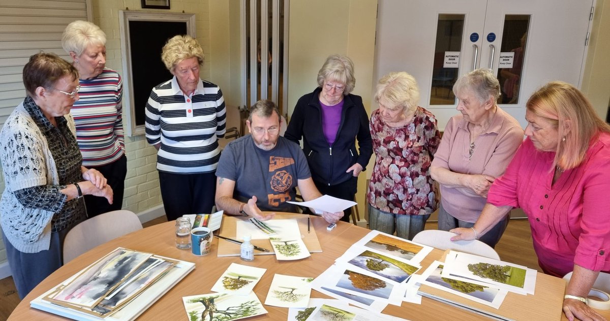 Trees are today's subject in Alan's art class. Everyone's listening intently as he says "green for the leaves, brown for the trunk..."
