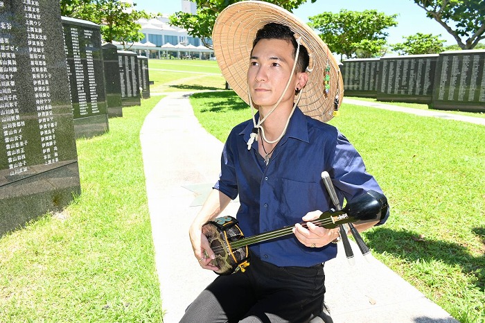 ryukyushimpo's tweet photo. 午後0時20分ごろ、糸満市の「平和の礎」では、親戚に三線で唄を捧げる宮古島市平良出身の24歳の男性の姿がありました。※漢字に誤りがありましたので再投稿しました。
#沖縄戦　#慰霊の日　#沖縄慰霊の日 #ドキュメント https://t.co/kI7wLMPr7b