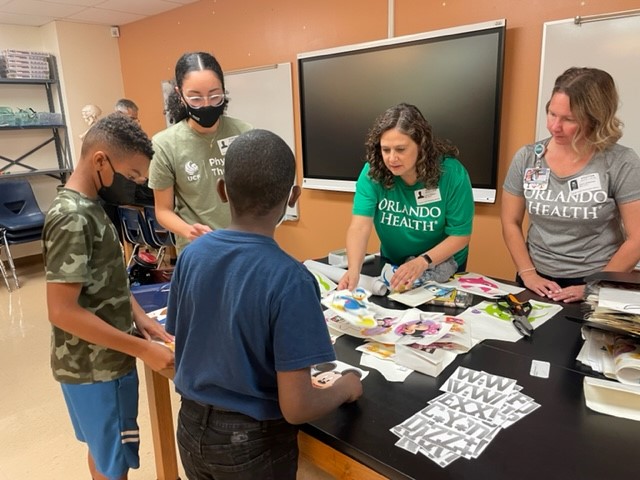 UCF_DPT's tweet photo. Orlando Health Community Benefit & @UCF_GoBabyGo came together to hold a Kids Building for Kids Workshop at Orange Center Elementary. Our students and clinicians worked side by side. Leo, the little driver in photos attached, was thrilled to receive his new wheels! #whyUCFDPT https://t.co/HdvVcNqBaj