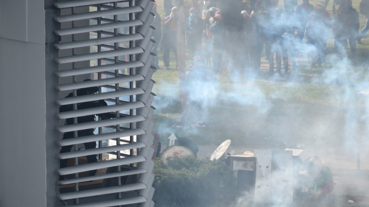 radiolacalle's tweet photo. #ALERTA | Policías  disparan gas lacrimógeno hacia los manifestantes desde el interior de la Contraloría General del Estado.
#ParoNacionalEcuador
#ParoNacionalEC 
#ParoEcuador2022 https://t.co/7zXgGc6HnS