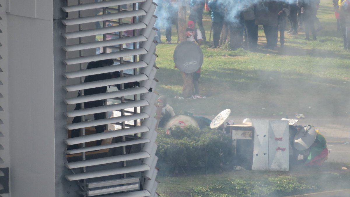radiolacalle's tweet photo. #ALERTA | Policías  disparan gas lacrimógeno hacia los manifestantes desde el interior de la Contraloría General del Estado.
#ParoNacionalEcuador
#ParoNacionalEC 
#ParoEcuador2022 https://t.co/7zXgGc6HnS