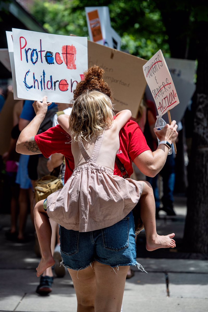 AngelaMWilhelm's tweet photo. Keverlee Burchett carries Erie Pope, 4, on her back as they rally during #MarchForOurLivesJune11 in #avl https://t.co/HttGnjkE4v