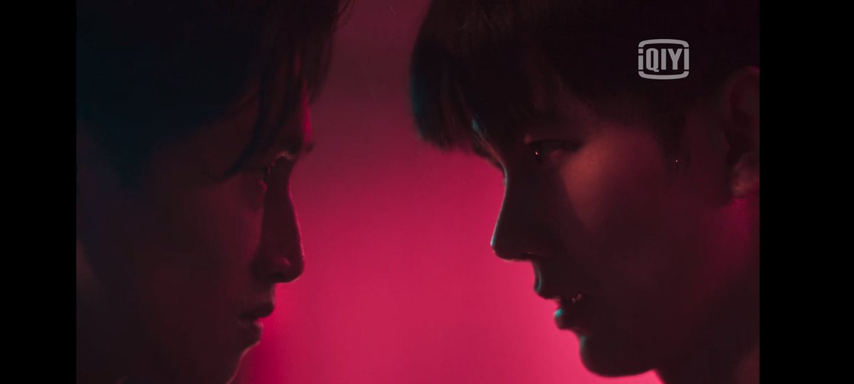 Glares at each other, in a reddish-colored room, representing the current situation. Too intense to behold. What is really going on with Vegas and Pete?