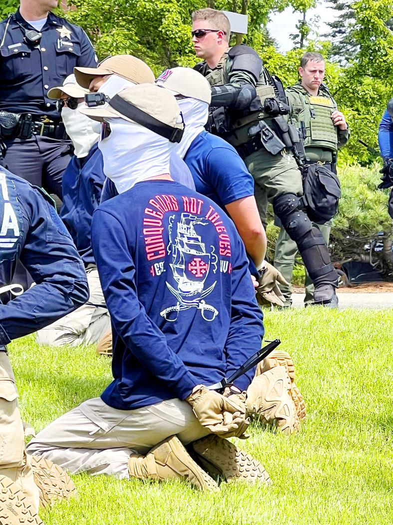 Admittedly I'm no expert on being arrested, but when they cuff you up, don't they normally remove your gloves, face mask and sunglasses?

Getting a suspicious feeling on this one.
