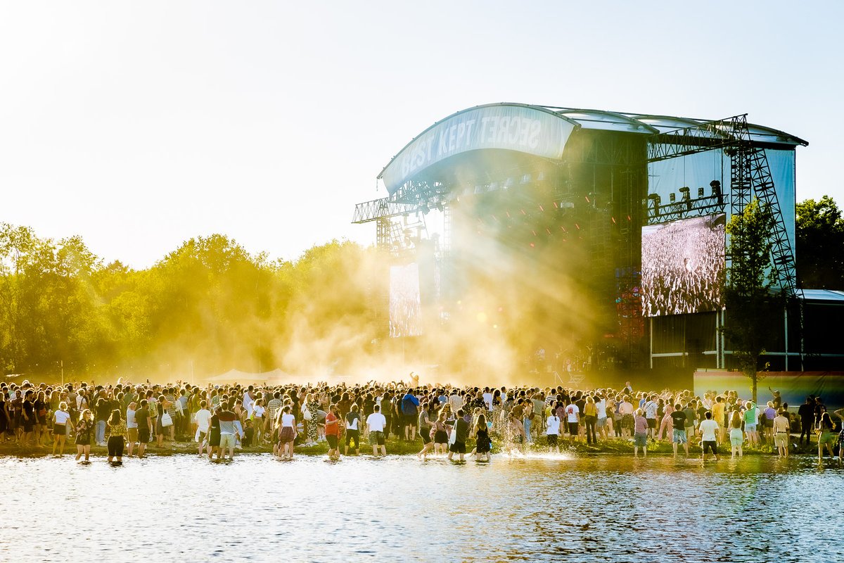 Benz's tweet photo. The magic happens during a golden sunset at the @BKSfestival
@kinggizzard gitarist and singer Stu Mackenzie crowd surfs towards the lake and takes a dive into the water.
#kinggizardandthelizardwizard #bestkeptsecret #bestkeotsecretfestival https://t.co/DCe5ZhpNn8