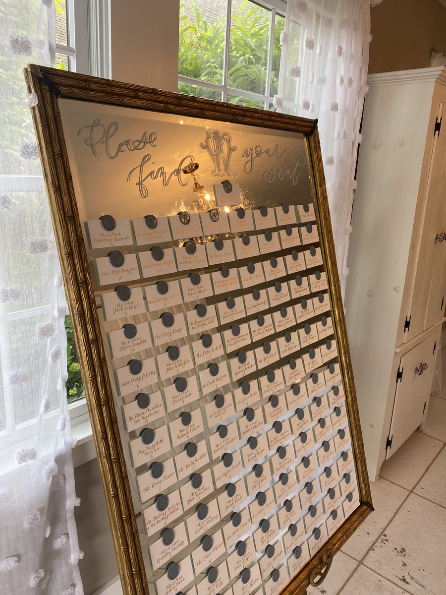 kristendip's tweet image. My largest installation to date: a mirror seating chart with escort cards and wax seals bearing the couple’s monogram. Every detail done by hand, from pressing all 121 wax seals, calligraphing each card, and calculating the math to make it all fit. #calligraphy #seatingchart