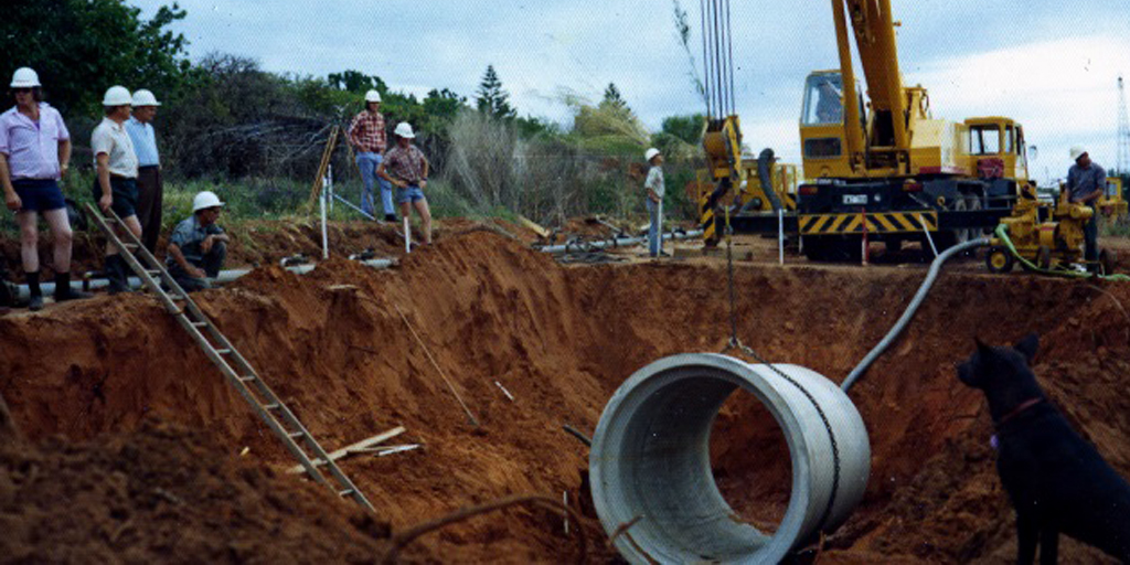 SAWaterCorp's tweet photo. Our crews in the 1970s certainly loved their short shorts! 🩳 Today, we certainly stick to trusty and safe long pants. 

Here, the team – including a furry site supervisor 🐶 – are installing a new concrete pipe in Berri.  

#TimewarpTuesday https://t.co/Tth3Waon0l