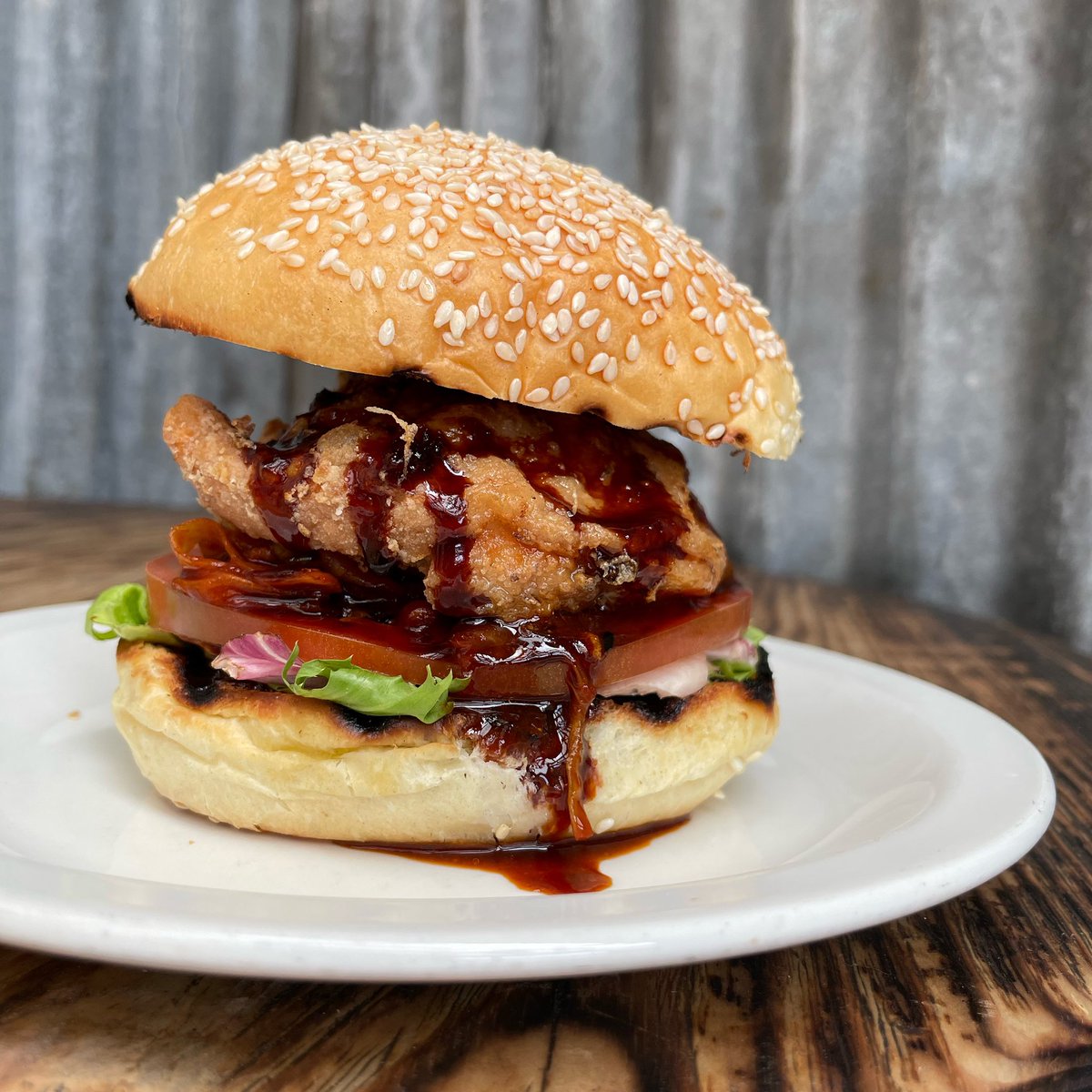 Cripsy chicken burger, house kimchi, spicy BBQ sauce, lettuce, tomato. New on the menu! Get yours tonight, kitchen till 10, bar till late. Give us a call to book or pop in and we’ll find you a spot. #neverforever #kentishtown #bar #food