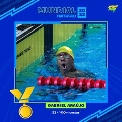 Card de medalha azul, com medalha dourada. Ao centro, foto de Gabriel Araújo, de touca amarela e óculos, comemorando na borda da piscina.