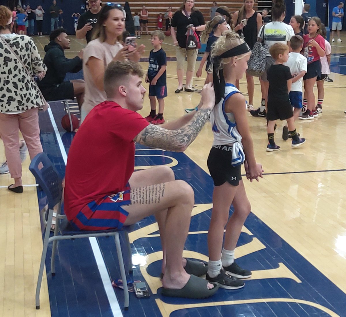 peterson_rick's tweet photo. . @KUHoops super senior @Cam_martin31 signs an autograph for a young fan during Tuesday's @IchabodMBB camp at Lee Arena. https://t.co/0eR0AidiH2