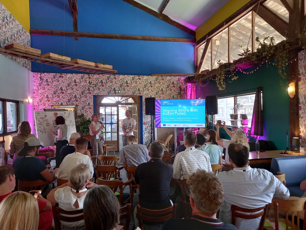 URBACT's tweet photo. Mats-Laes Nuter on localising #SDGs: "It's about aligning plans at city level with national and global goals" To save time Tallinn 2035 strategy informs one comprehensive monitoring system: it could have about 600 KPIs, about a third could be used in SDG monitoring #URBACTfest https://t.co/majHMIlf84