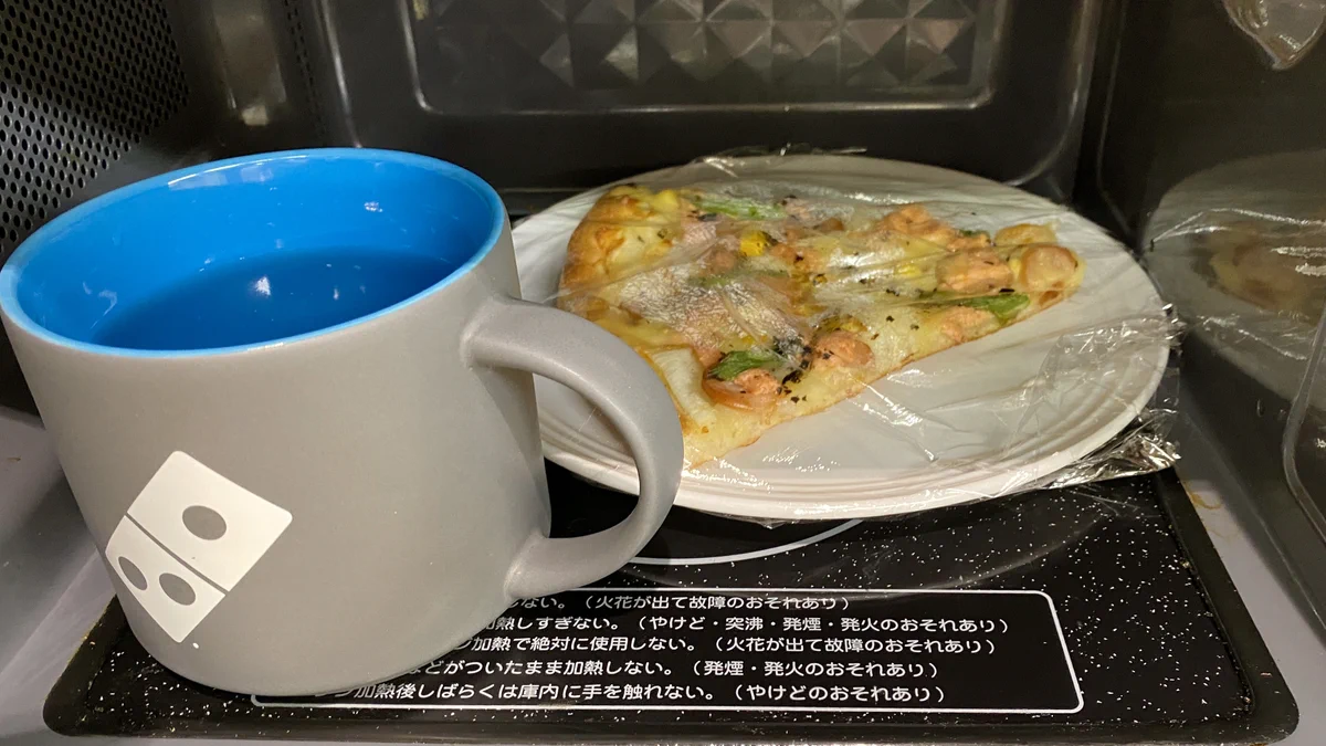 コップに水を入れピザと一緒に500Wで1分弱レンジで温めるとふわふわピザに蘇える‼