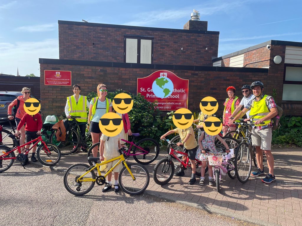 Group of children stood at school with their bikes wearing high viz