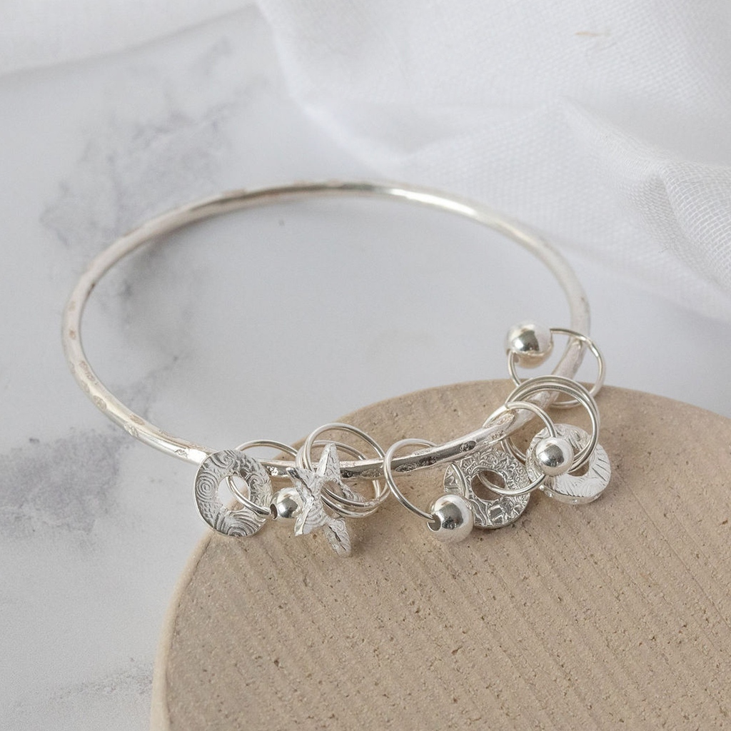 LucyKjewellery's tweet photo. We love the 'jingle jangle' of bangles! Who's with us? Stack them up or incorporate one with multiple charms such as our gorgeous Sterling Silver Charm Bangle. Handmade in sterling silver with individually cut out stars, circles and beads. 🤍 #charmbangle #sterlingsilverbangle https://t.co/VA2PJweVvn