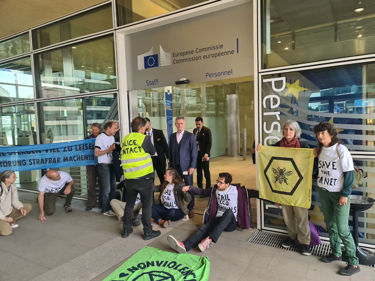 BREAKING: XR blockiert den Eingang der EU-Kommission in #Brüssel 40 Aktivist:innen von XR Europa blockieren den Eingang zum Gebäude der @EU_Commission. 10 Aktivisti haben sich mit Sekundenkleber an die Eingangstüren geklebt. Wir fordern ein Ökozidgesetz! #EUstopEcocriminals