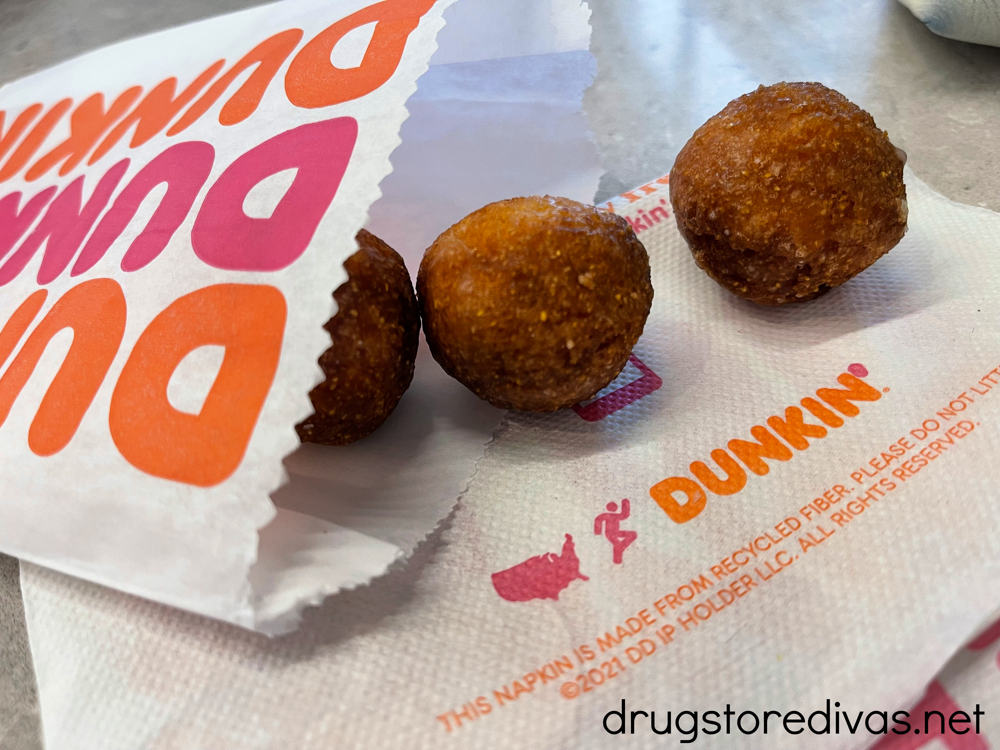 Three Dunkin' munchkins and their packaging.