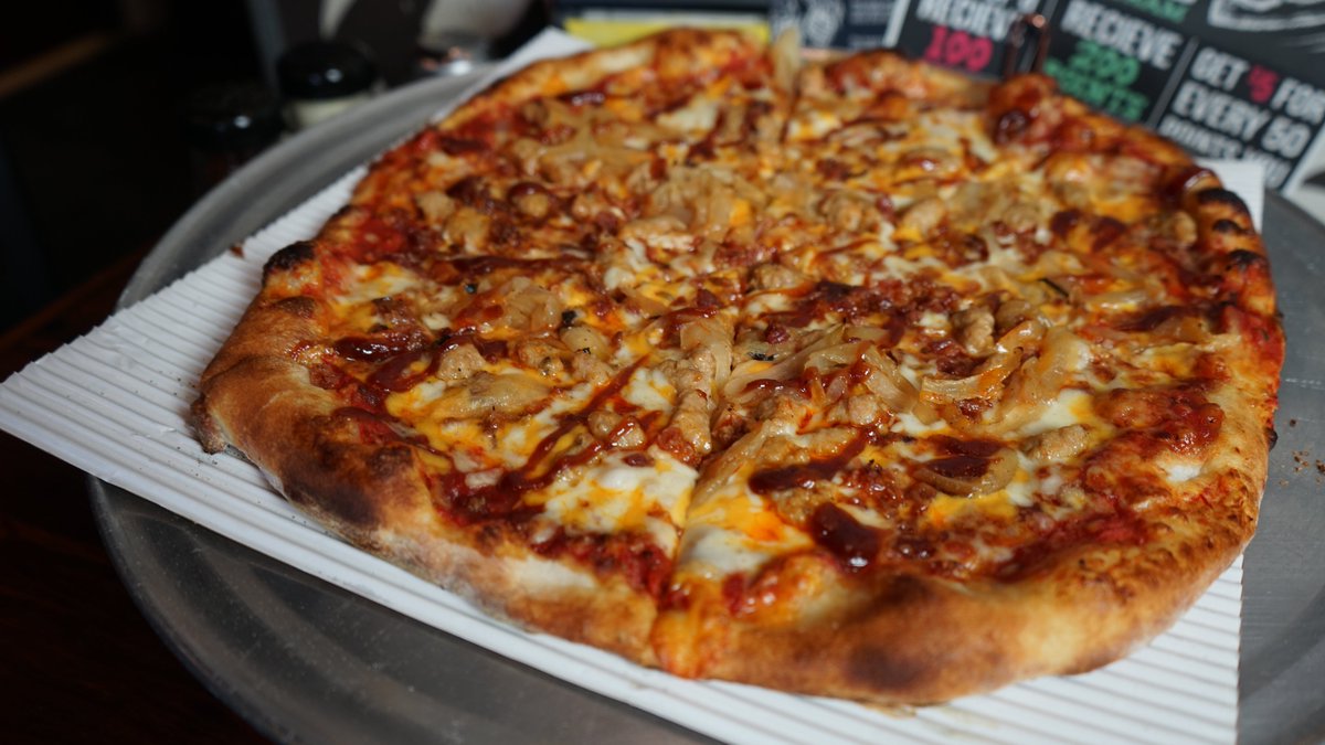 Our Smoke N Bones Pizza: smoky marinara sauce, cheddar cheese, sausage, applewood smoked bacon, caramelized onions, and chili oil. Irresistible flavors!