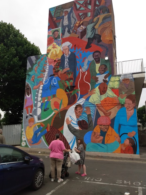 SalterCentenary's tweet photo. The mural with Ada at its centre is now finished! At The Blue Market Place in Bermondsey, by Paul Butler. Here it is being admired by the local girl who painted the daisies in the left-hand corner (to match those on her dress). https://t.co/ECGEpAENAC
