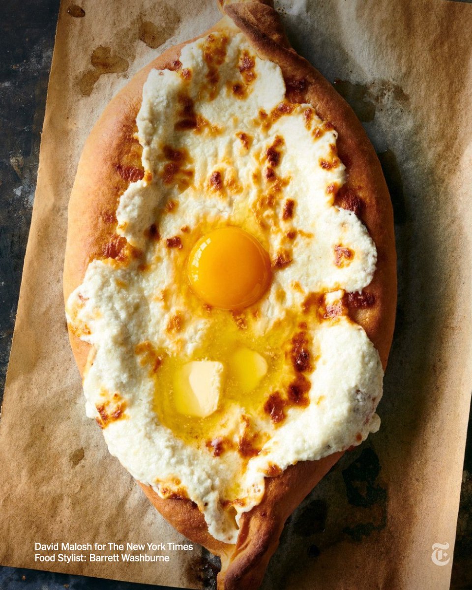 nytimes's tweet photo. To serve this Georgian dish known as khachapuri adjaruli, you drop an egg yolk and some cold butter into the molten cheese and stir it into a gooey, stretchy cheese puddle. 

Full recipe: https://t.co/8OlWy5Qd16 https://t.co/mbVB0H3nZE