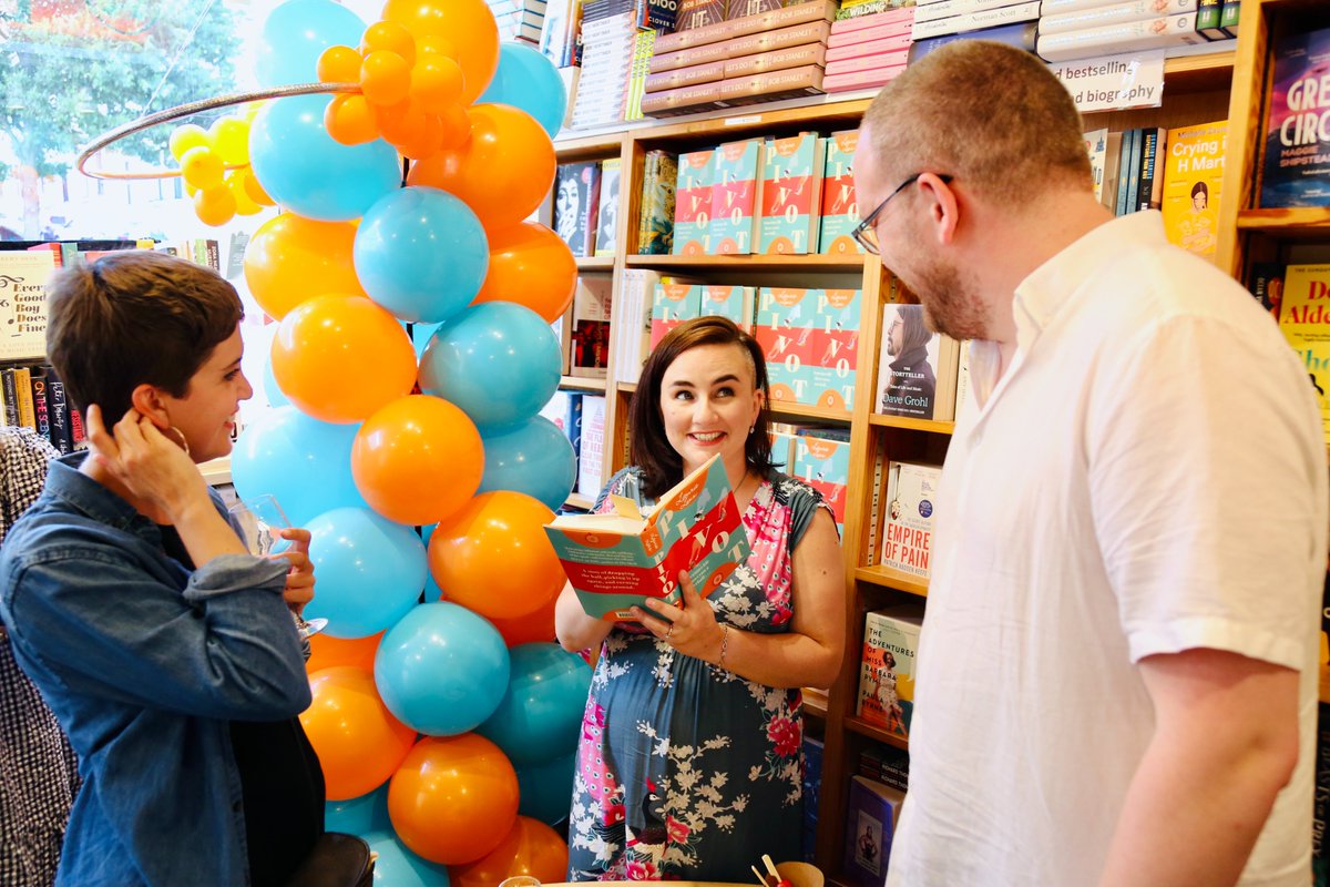 Inside the book shop, I am signing a copy of Pivot and smiling up at my husband Tom next to a load of balloons. Sarah, from Two Roads, is smiling and talking to us.