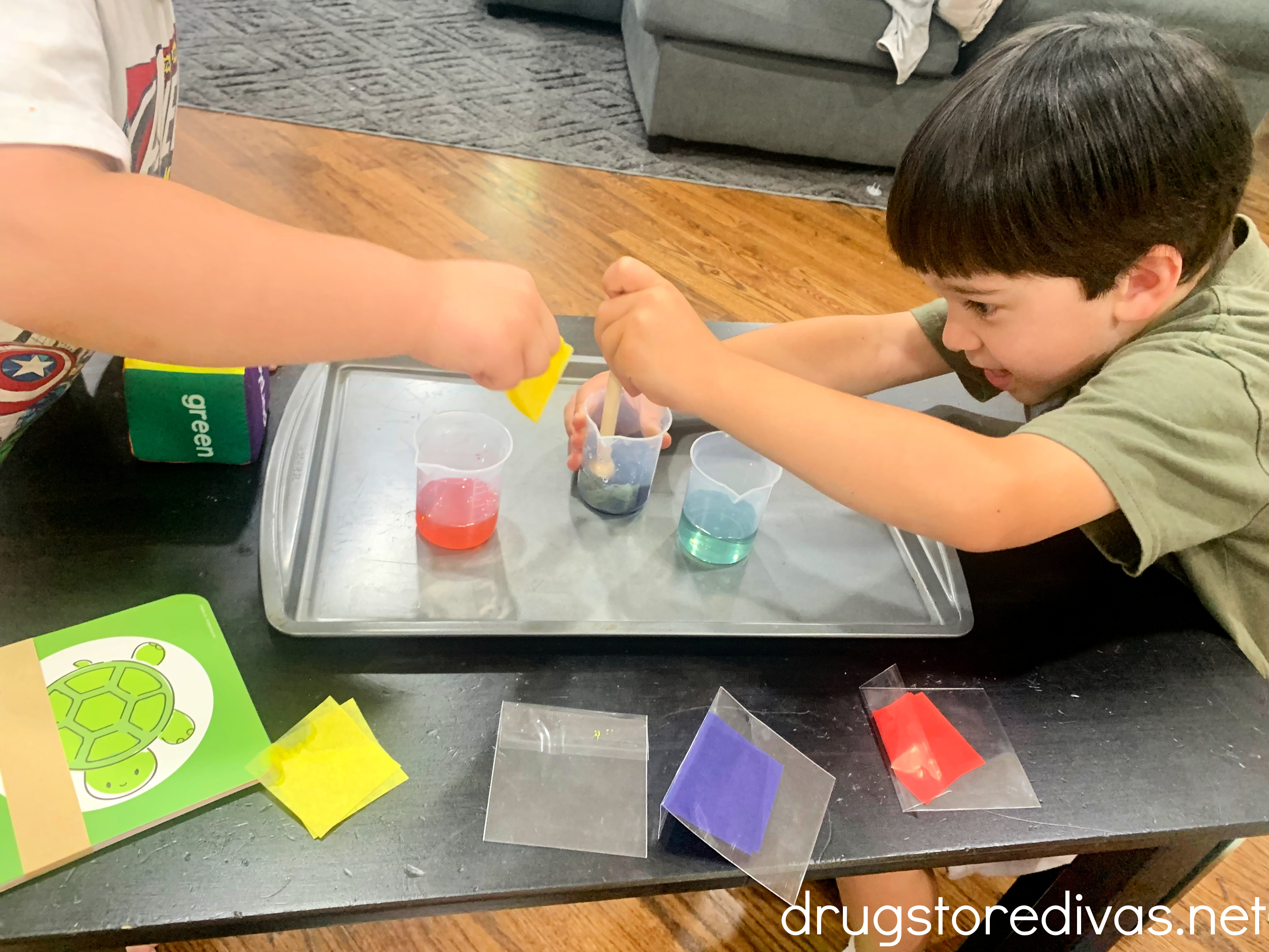 Two boys playing with items from a KiwiCo box.