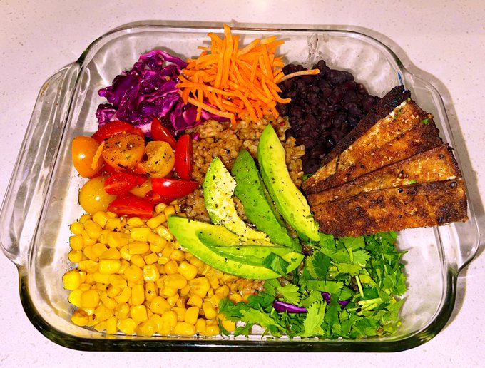 Food tastes so much better when it’s pretty ? ?  brown rice , avo, corn , cilantro, tomatoes , red cabbage