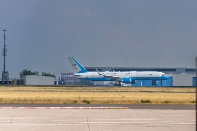 Secretary Blinken's airplane departs airport roadway with "United States of America" painted on its side.